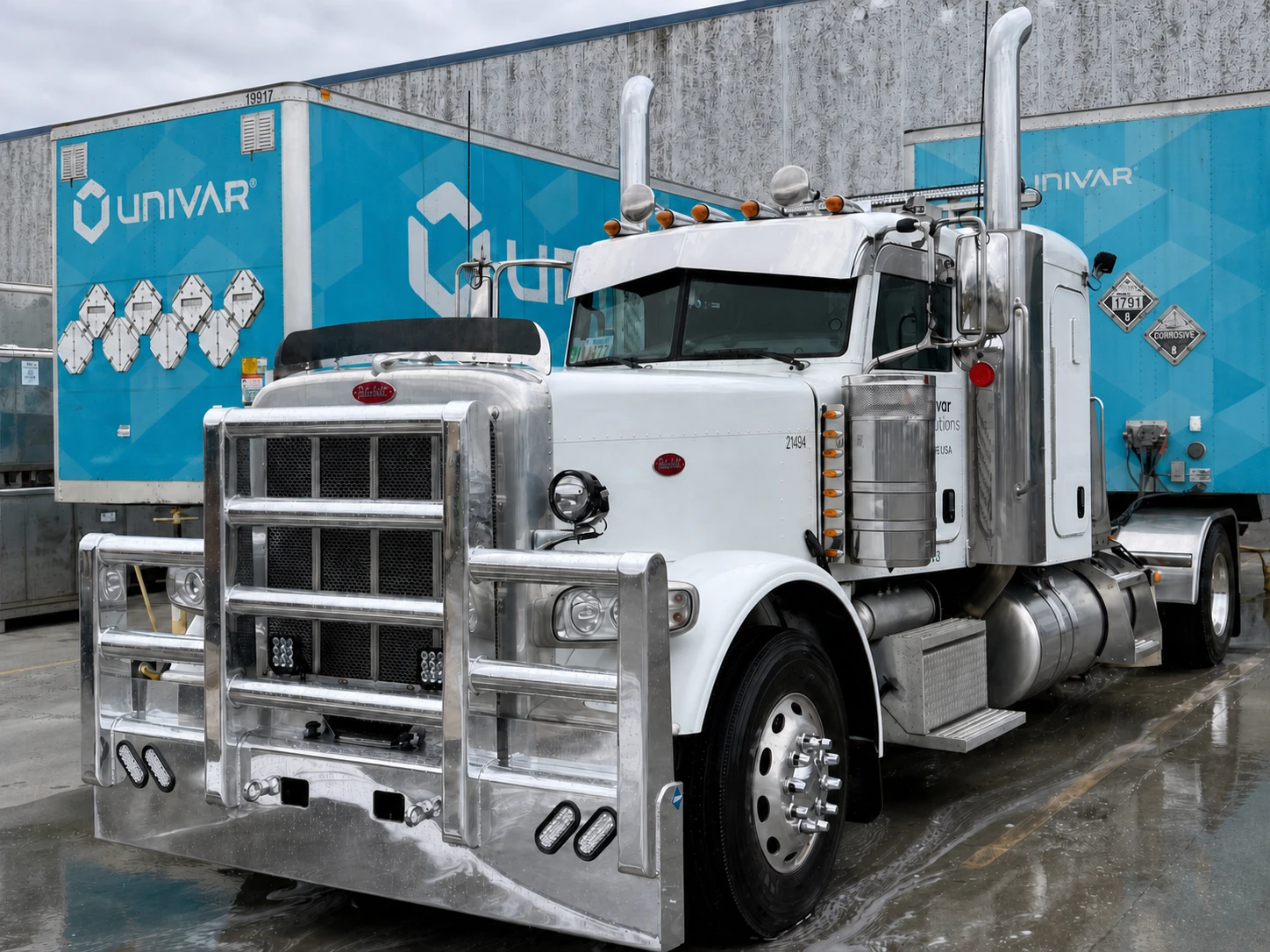 Freshly detailed white Peterbilt fleet truck on wet, soapy pavement at the UNIVAR facility