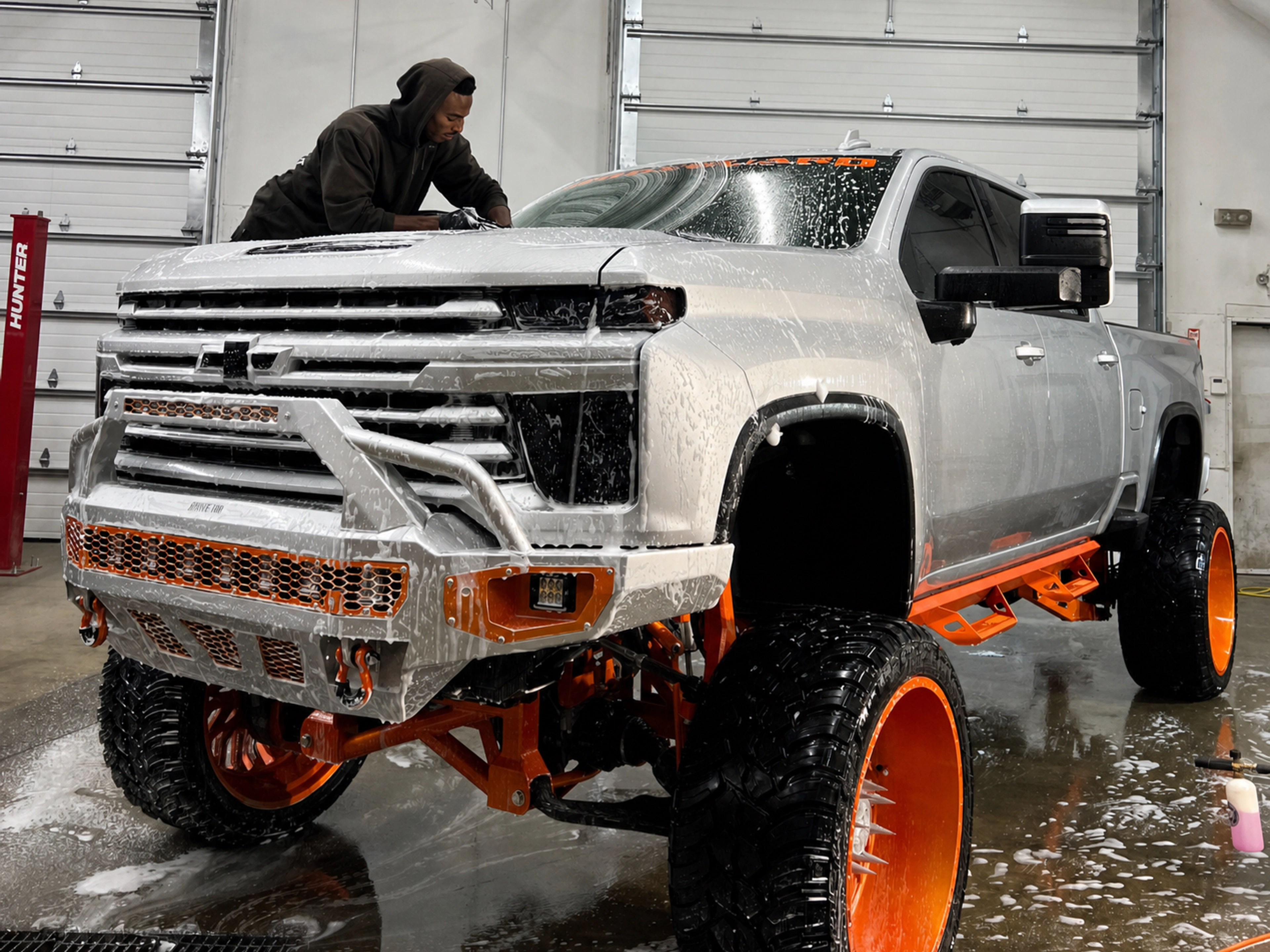 Owner hand-washing a custom lifted truck